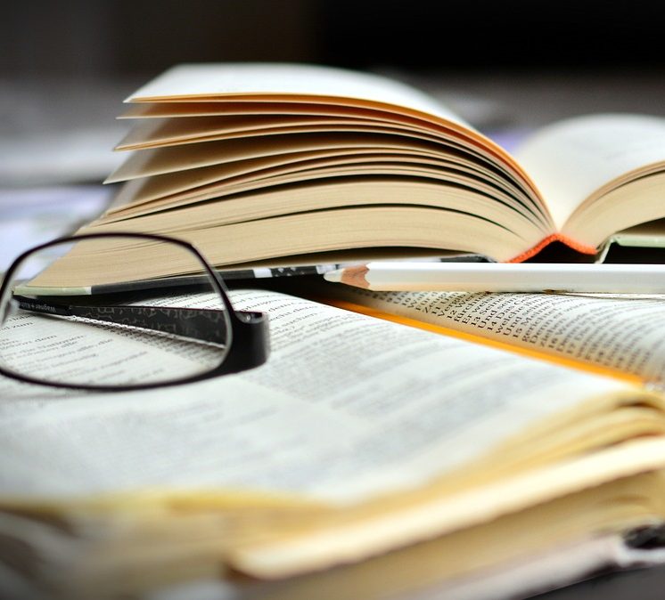 Ein Symbolbild für Studium mit Büchern und einer Brille.