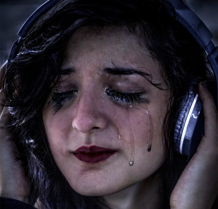 Weinende Frau, deren Emotionen durch Musik ausgelöst wurden.